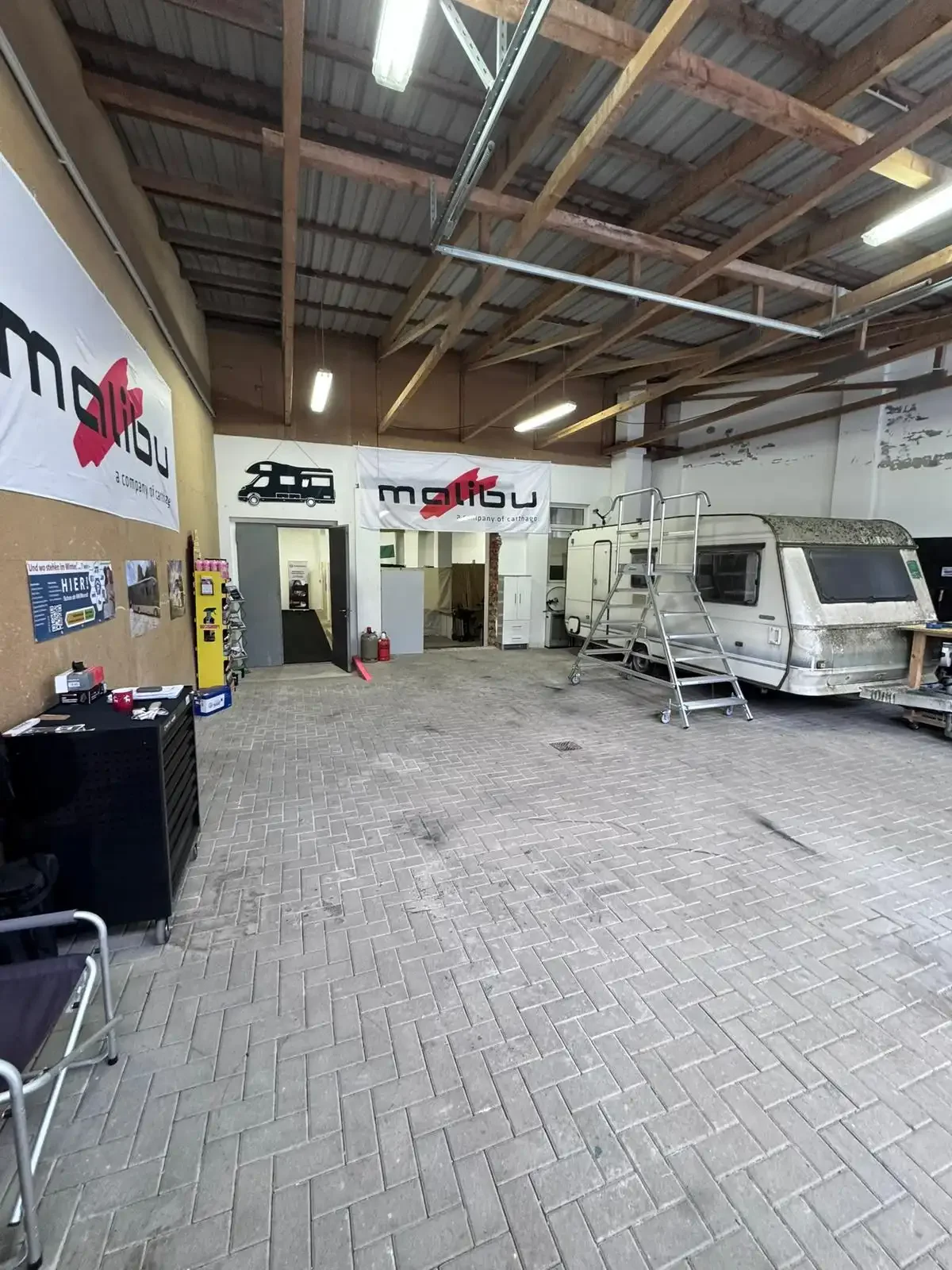 Büro mit Tisch, Stühlen und Wohnmobil-Unterlagen.