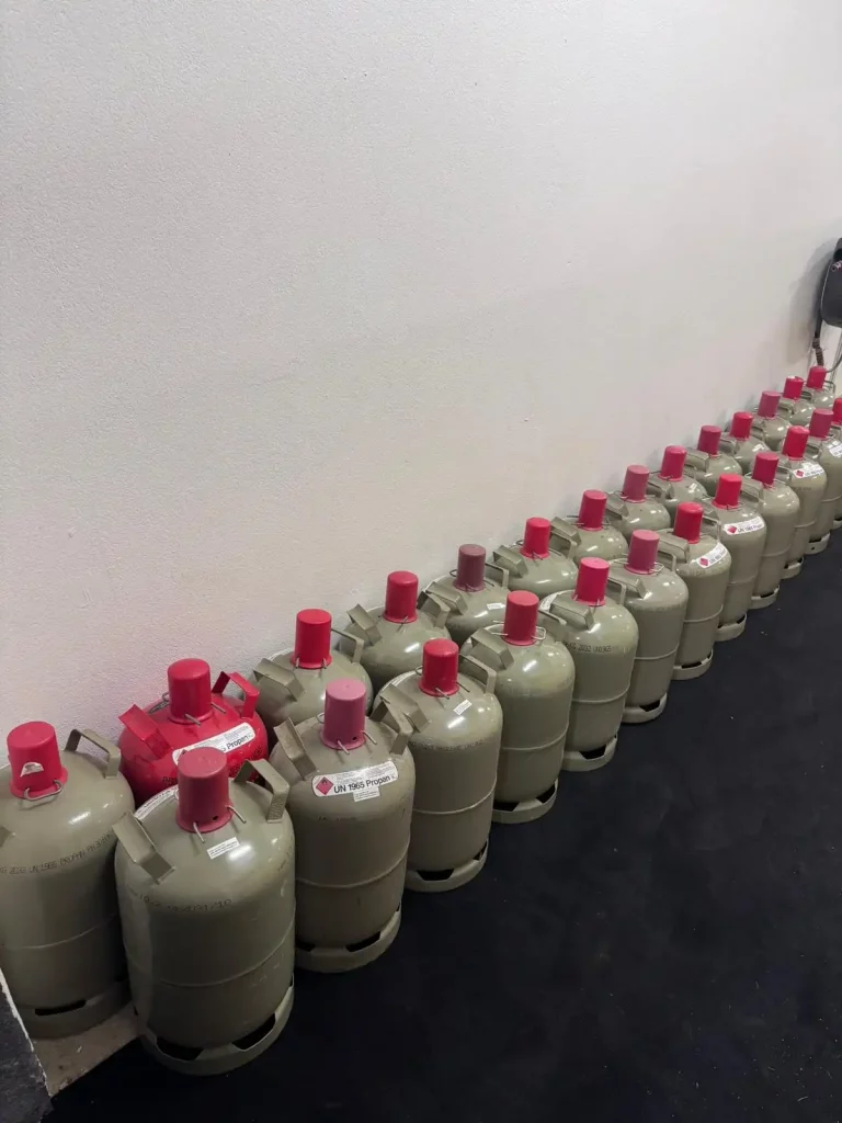 Mehrere Flaschen Reinigungsmittel mit rotem Verschluss in Reihe aufgestellt.